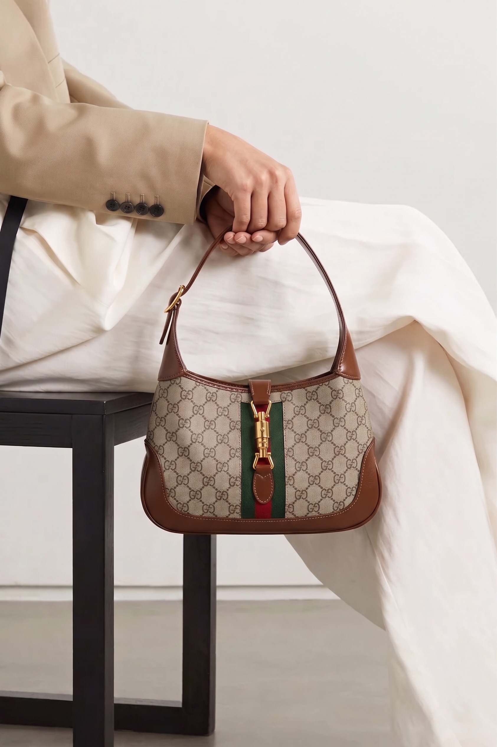 Especialista segurando uma bolsa de luxo durante atendimento personalizado